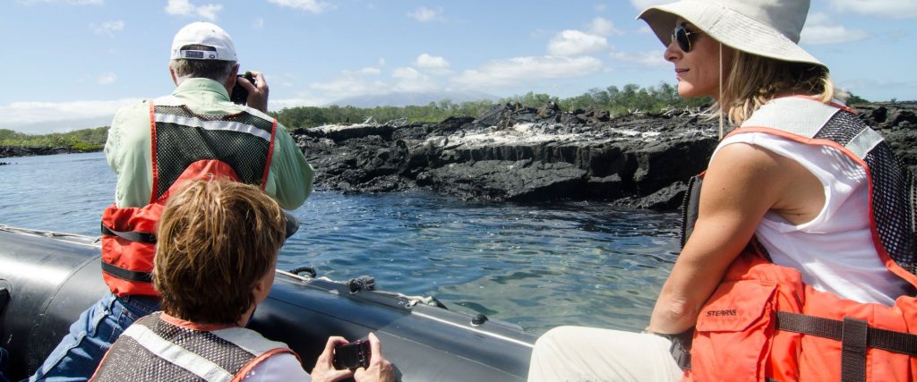 Grupo de viajeros en una expedición por las Islas Galápagos, explorando la fauna y los paisajes volcánicos.