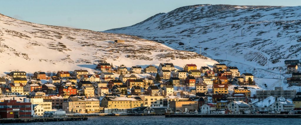 Vista panorámica de un pueblo noruego con montañas y nieve.